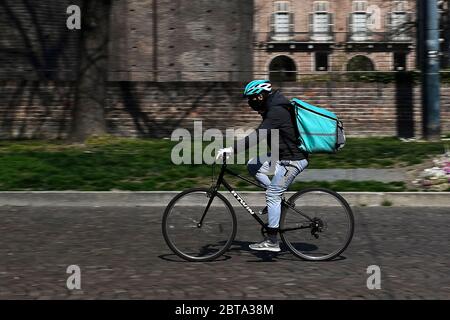 Torino, Italia - 18 marzo 2020: Un pilota di cibo Deliveroo corre durante il suo lavoro. Il governo italiano ha imposto restrizioni senza precedenti per fermare la diffusione dell'epidemia di coronavirus COVID-19, tra le altre misure i movimenti di persone sono consentiti solo per lavoro, per l'acquisto di beni essenziali e per motivi di salute. I ristoranti sono chiusi ai clienti, sono consentite solo consegne a domicilio. Credit: Nicolò campo/Alamy Live News Foto Stock