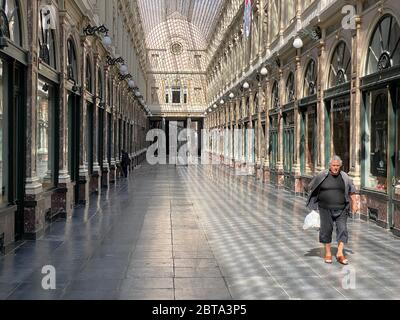 Bruxelles, Belgio, 25 aprile 2020 - una persona che cammina da sola all'interno della galleria commerciale di lusso Les Galeries Royales Saint-Hubert durante il con Foto Stock