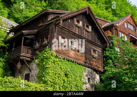 Vista esterna di un'antica casa in legno tradizionale costruita sulla cima di una roccia cresciuta nel famoso villaggio montano Hallstatt, Salzkammergut, OÖ, Austria Foto Stock