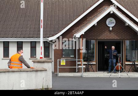 Il pastore Brian Madden (a destra), che si è ripreso dal Covid-19, predica durante un viaggio in servizio alla chiesa pentecostale di Maghaberry Elim, Craigavon, poiché alcune chiese stanno riavviando i servizi di drive-in a seguito dell'allentamento delle restrizioni in Irlanda del Nord a causa della pandemia del coronavirus. Foto Stock