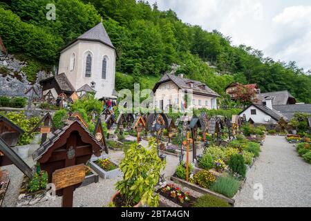 Vista sul cimitero che circonda la chiesa parrocchiale cattolica romana di Hallstatt, regione di Salzkammergut, OÖ, Austria, con la famosa casa di charme Foto Stock