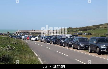 Parcheggi e verge affollati mentre le persone parcheggiano a Birling Gap vicino Eastbourne, mentre le persone viaggiano verso spiagge, parchi e luoghi di bellezza con misure di blocco attenuato. Foto Stock