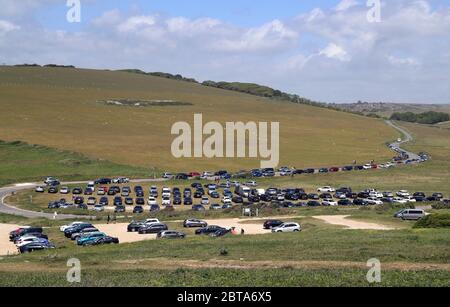 Parcheggi e verge affollati mentre le persone parcheggiano a Birling Gap vicino Eastbourne, mentre le persone viaggiano verso spiagge, parchi e luoghi di bellezza con misure di blocco attenuato. Foto Stock