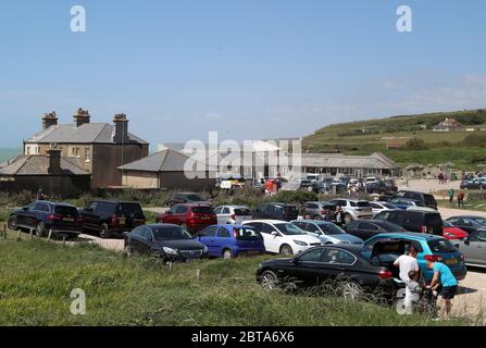 Parcheggi e verge affollati mentre le persone parcheggiano a Birling Gap vicino Eastbourne, mentre le persone viaggiano verso spiagge, parchi e luoghi di bellezza con misure di blocco attenuato. Foto Stock