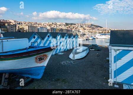 Napoli, 9 febbraio 2020 – una colorata barca da pesca e cabine da bagno sulla spiaggia di Mergellina Foto Stock