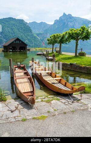 Vista di due tradizionali barche a fondo piatto in legno "Plätten", che si siedono sul lungolago del Traunsee a Traunkirchen, regione del Salzkammergut, Austria Foto Stock