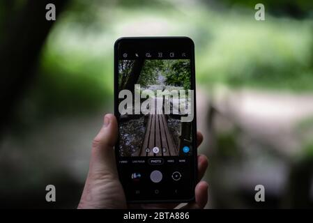 Il mondo visto attraverso lo schermo di uno smartphone Foto Stock