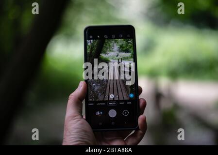 Il mondo visto attraverso lo schermo di uno smartphone Foto Stock