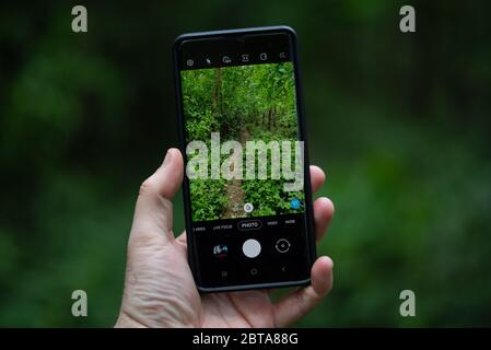 Il mondo visto attraverso lo schermo di uno smartphone Foto Stock