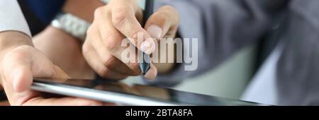 L'uomo tiene lo stilo e inserisce la firma sul tablet Foto Stock