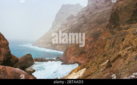 Santo Antao. Capo Verde. Splendido paesaggio della costa. Ripide scogliere nere si stese in avanti, enormi onde che si infrangono contro ripide coste rocciose Foto Stock