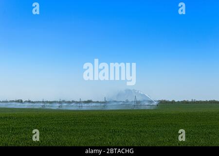 Sistema di irrigazione o irrigazione del raccolto centrale per la gestione dell'azienda irrora l'acqua sul campo Foto Stock