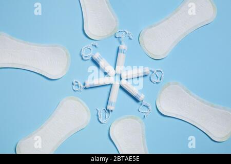 Modello con tamponi in cotone bianco sanitario e tamponi su sfondo blu. Prodotti per l'igiene femminile Foto Stock