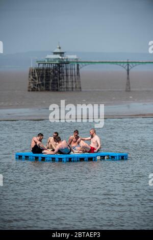 Un gruppo di giovani uomini gode del sole nel lago marino di Clevedon nel Somerset dopo che le restrizioni di blocco sono state attenuate in Inghilterra la settimana scorsa. Foto Stock