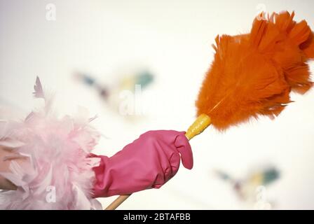 Guanto in gomma di novità che indossa una mano che tiene un piumino Foto Stock