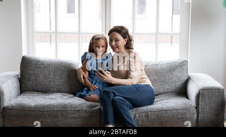 Cura di una bambina matura con smartphone e nipote Foto Stock