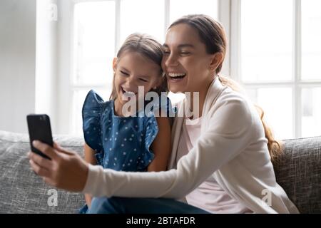 La mamma e la bambina si sono molto gioite usando insieme il gadget Foto Stock