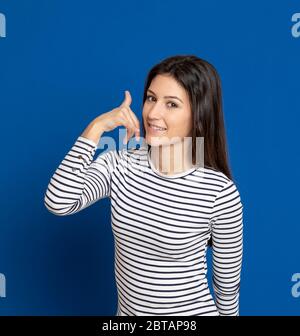 Giovane donna bruna con una T-shirt a righe su sfondo blu Foto Stock