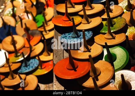Vista dall'alto su colorati giocattoli in legno dipinti a mano - cime dei pioli o capricci, come sfondo creativo con bokeh dorato chiaro sfocato Foto Stock