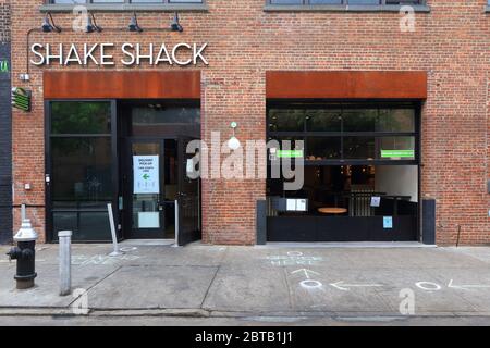 A Shake Shack nel quartiere Williamsburg di Brooklyn, con circoli di distanza sociali in gesso e finestre separate per il prelievo, la consegna e l'ordinazione Foto Stock