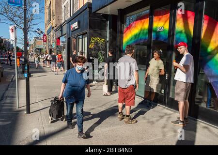 Montreal, CA - 23 Maggio 2020 : clienti in una linea esterna al negozio di liquori SAQ a Montreal Foto Stock