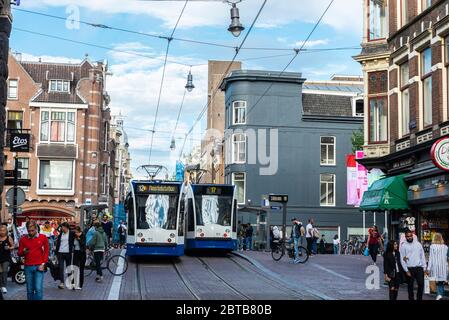 Amsterdam, Paesi Bassi - 9 settembre 2018: Due tram circolanti e persone che camminano in via Leidsestraat, Amsterdam, Paesi Bassi Foto Stock