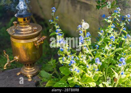 Vecchio samovar d'annata con fumo. Preparare il tè in vecchio stile. Cerimonia russa Foto Stock