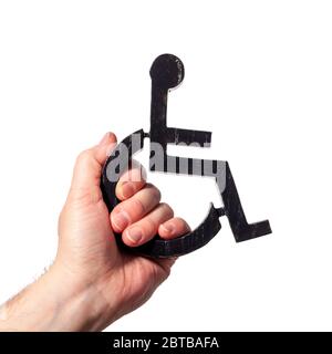 Simbolo disabilitato che è tenuto in su la mia mano umana. Il potere alle persone disabili firma su uno sfondo bianco Foto Stock