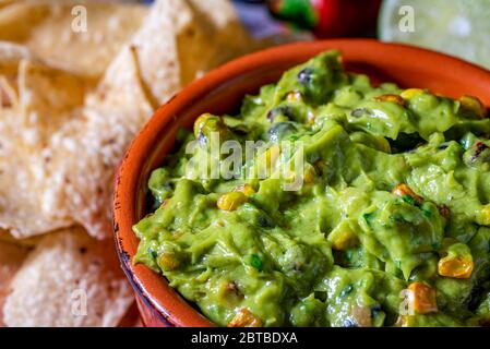 Salsa di guacamole con mais arrosto e ingredienti crudi Foto Stock