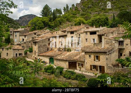 Antiche case medievali in pietra nel villaggio francese di St-Guilhem-le-Désert. Foto Stock