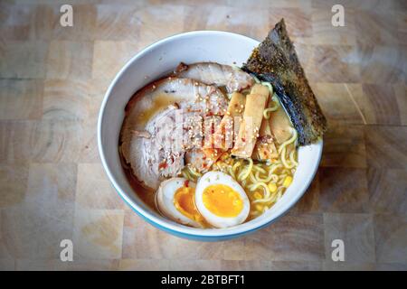 Primo piano di una ciotola di ramen di Hokkaido in una ricca zuppa di miso con zuppa di Char Siu giapponese o di maiale giapponese, uova di tuorlo morbido, germogli di bambù, alghe Foto Stock