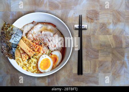 Ciotola di ramen di Hokkaido in una ricca zuppa di miso con zuppa di maiale giapponese o char Siu fatta in casa, uova di tuorlo, germogli di bambù, alghe marine e sesamo Foto Stock