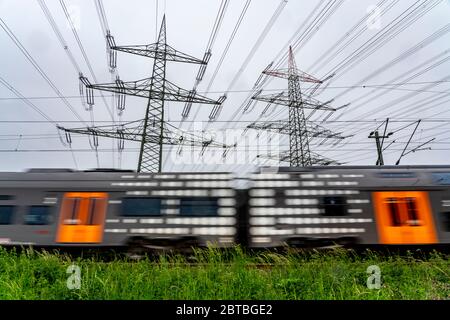 Treno sulla linea tra Essen e Bochum, linee elettriche, rete ad altissima tensione, 380 kilovolt, trasporta l'elettricità generata in una grande centrale elettrica Foto Stock
