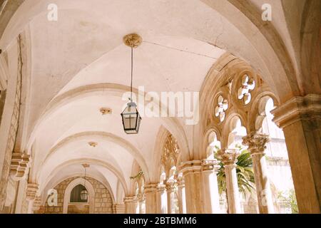 Colonne e archi di un cortile con un giardino del monastero domenicano a Dubrovnik, Croazia. Foto Stock