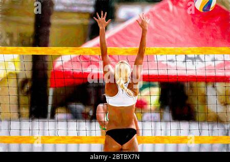 Un giocatore di Beach volley femminile sta humping alla rete per bloccare la palla di volo Foto Stock