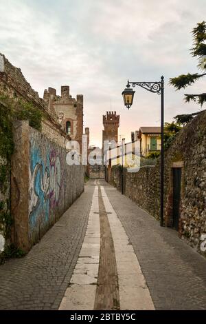 Un vicolo stretto nel centro storico con il castello medievale Scaligero e le mura cittadine, Lazise, Verona, Veneto, Italia Foto Stock