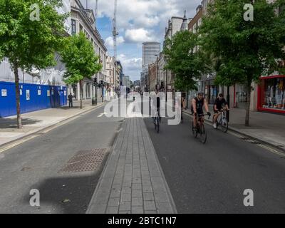 Londra. REGNO UNITO. 24 maggio 2020 alle 14:00. Vista delle persone in bicicletta a Oxford Street durante l'epidemia. Si tratta di un'area commerciale e commerciale sempre molto