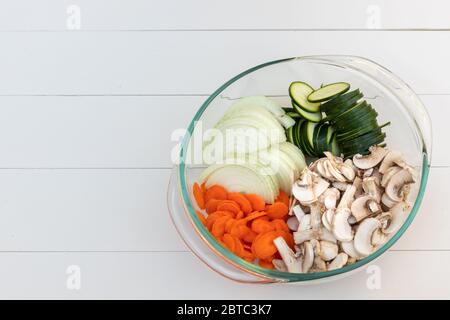 Ciotola di verdure appena affette-- cipolle, zucchine, funghi, carote-- per ingredienti Stir-Fry Foto Stock