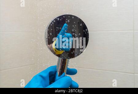 doccia annaffiatoio in mani con guanti di gomma. riflesso di una mano che fa un gesto gentile. Foto Stock