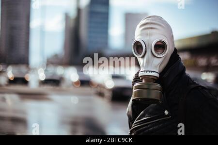 giovane uomo casual in una maschera a gas guardando la macchina fotografica Foto Stock