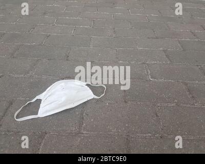 primo piano. maschera protettiva indossata sul marciapiede Foto Stock