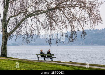 Una vecchia coppia rilassante sul Seaside Bench Foto Stock