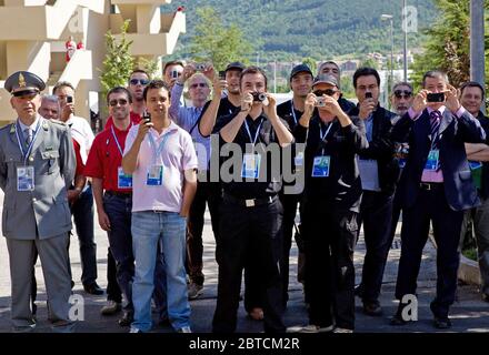 Gli astanti osservare il Presidente Barack Obama come egli cammina intorno al vertice del G8 nel sito di L'Aquila, Italia, Luglio 9, 2009. Foto Stock