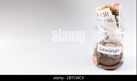 Manciata di monete e banconote in un vaso su sfondo bianco e spazio per la copia Foto Stock