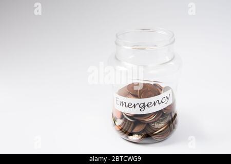 Denaro moneta risparmio in un vaso verso il fondo di emergenza Foto Stock