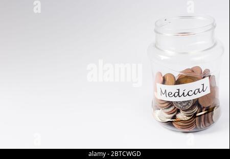 Spese mediche salvando i penny in vaso trasparente di moneta Foto Stock