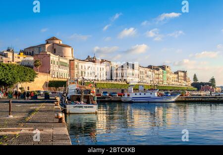 Siracusa / Italia - Dicembre 28 2015: Vista sul lungomare di Ortigia con le persone che si godono le vacanze di stagione in un pomeriggio di sole. Foto Stock