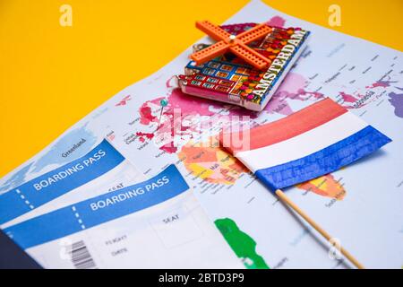 Concetto di viaggio nei Paesi Bassi, passaporto con carta d'imbarco, magnete da amsterdam e mappa mondiale della bandiera Foto Stock