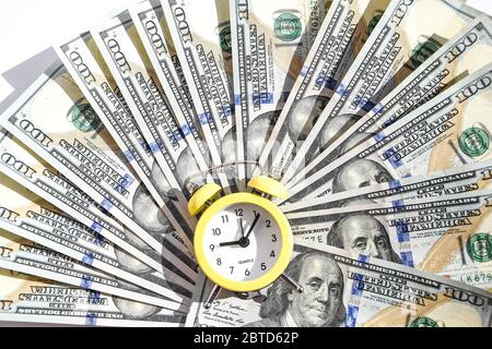 idee finanziarie di affari con lo stack delle banconote e lo sfondo dell'orologio di allarme con lo spazio libero della copia per il testo di creatività. il tempo è soldi Foto Stock