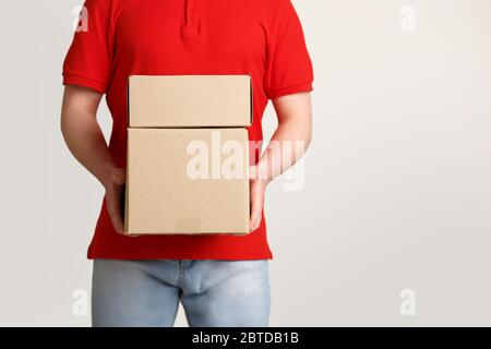 Shopping online, spedizione e corriere. Il deliveryman n Uniform contiene scatole Foto Stock